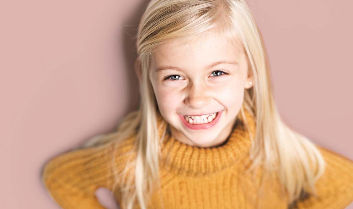 Blonds Mädchen vor pinkem Hintergrund. 