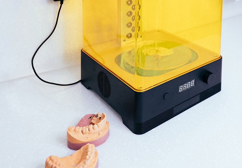 3D-Drucker mit Bissformen daneben.
