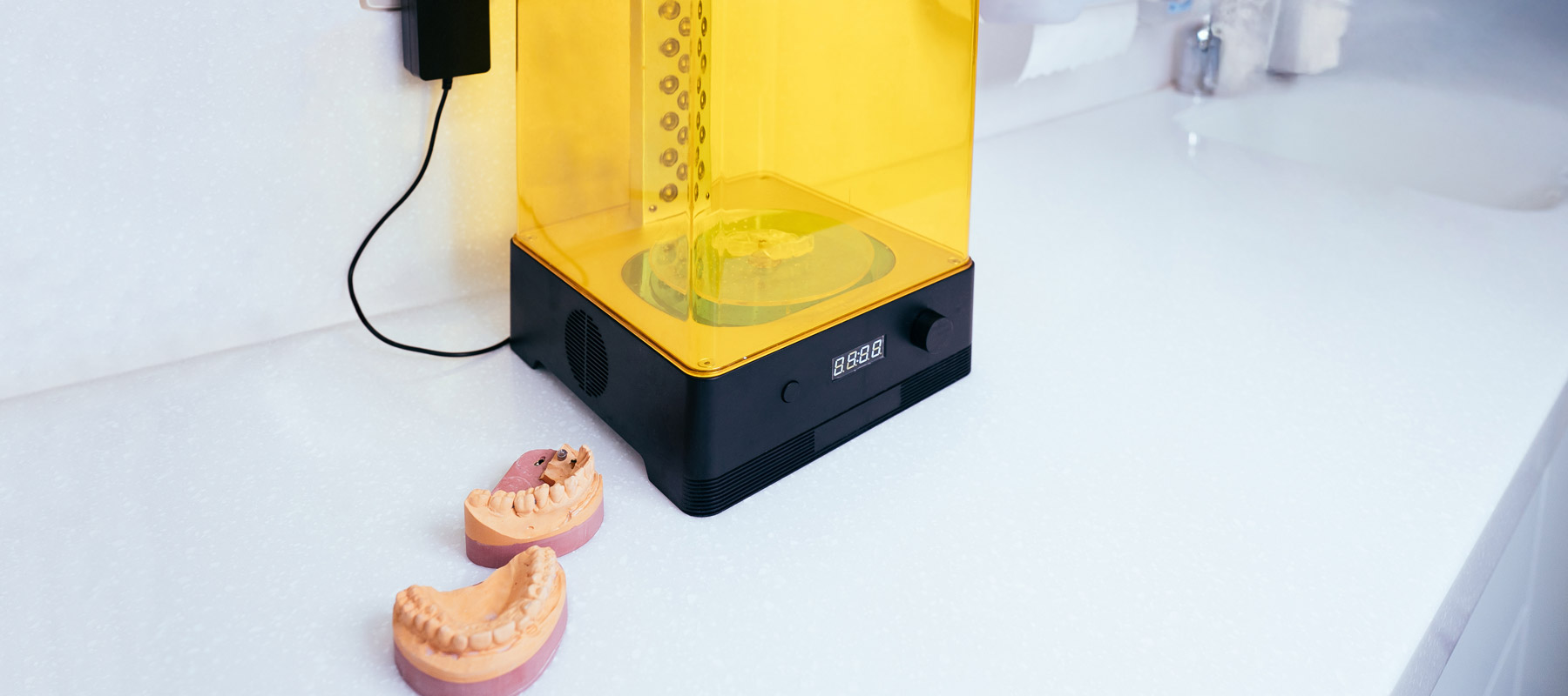 3D-Drucker mit Bissformen daneben.